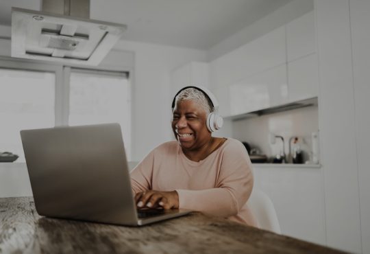 Older woman using laptop in kitchen