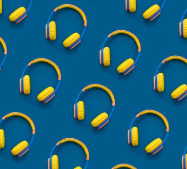 Pattern of multi-colored headphones on blue background.