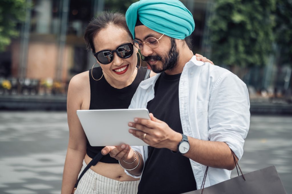 Man and woman walking and looking at digital tablet