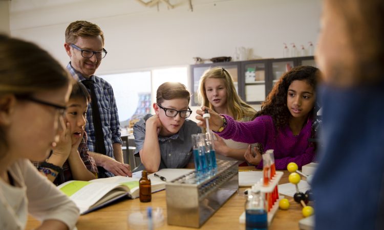 Middle school teacher and students conducting scientific experiment