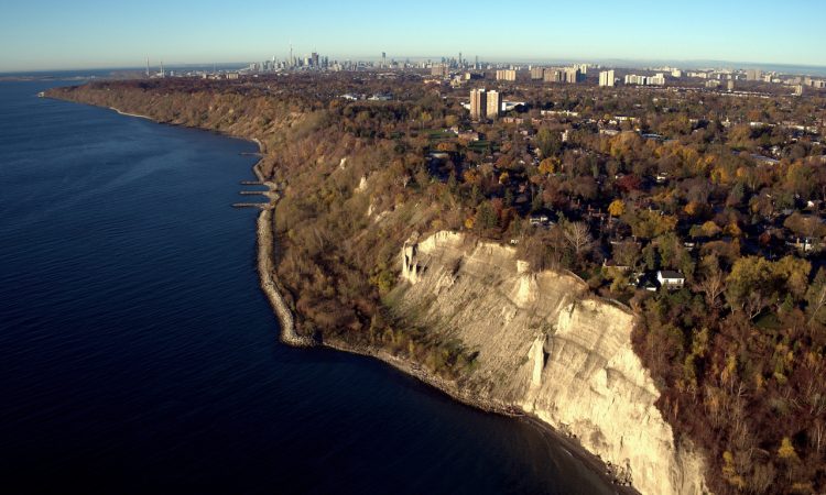 Aerial view of Scarborough Bluffs with Toronto downtown as far away background.