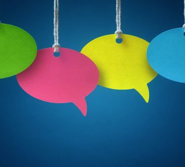 Blank colorful speech bubbles hanging from a cord over blue background