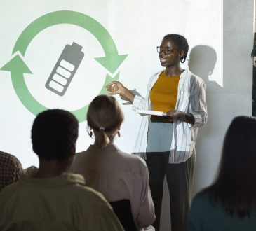 Portrait of young African-American woman giving speech on renewable energy during recycling and waste management conference