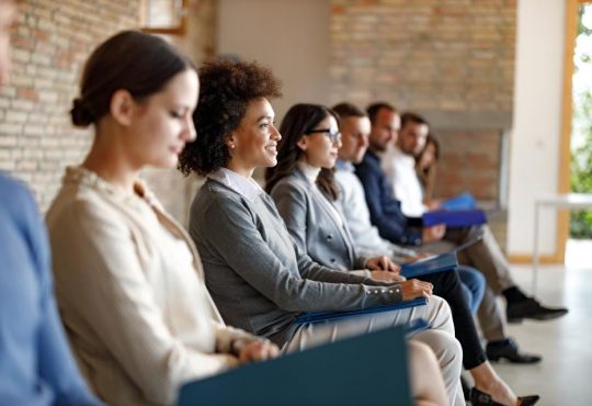 People sitting waiting to be called in for job interview