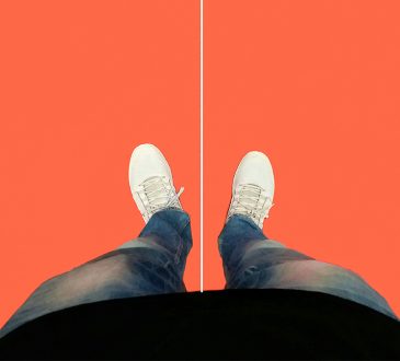 Legs and feet seen from top down standing on orange floor