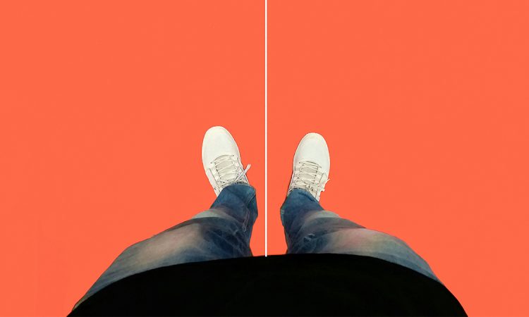 Legs and feet seen from top down standing on orange floor