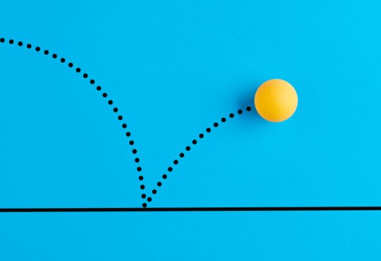 Yellow ping pong ball bouncing on blue background