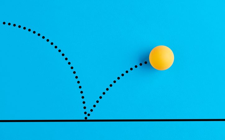 Yellow ping pong ball bouncing on blue background