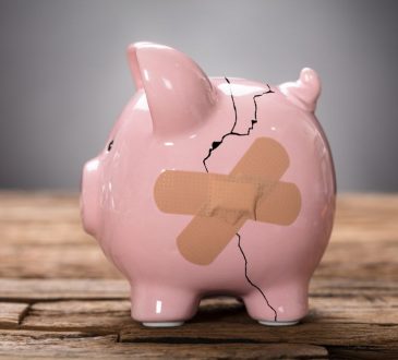 Cracked piggy bank with bandages