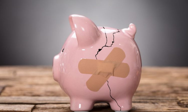 Cracked piggy bank with bandages