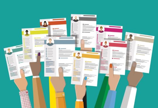 Illustration of many hands holding up resumes