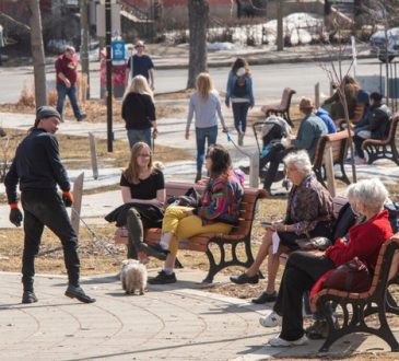 People sitting on benches and walking through park