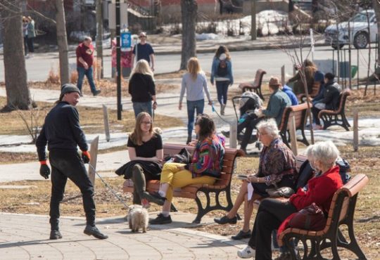 People sitting on benches and walking through park