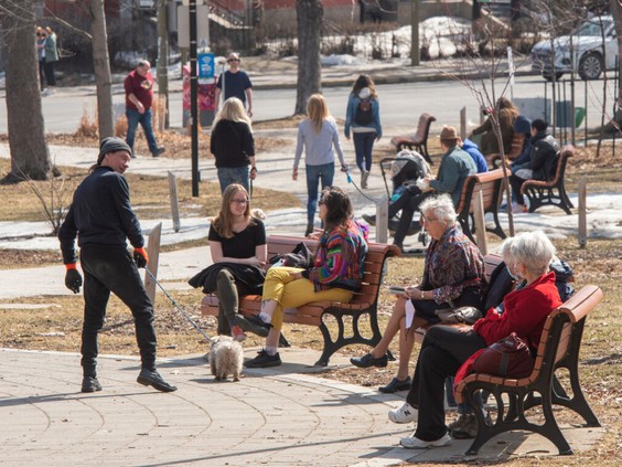 People sitting on benches and walking through park