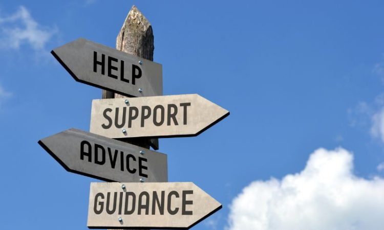 Signpost on background of blue sky with arrows reading "Help," "Support," "Advice" and "Guidance"