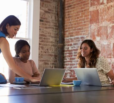 Three women working at table in office