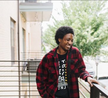 Portrait of person standing on apartment balcony