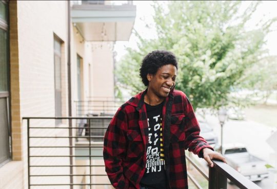 Portrait of person standing on apartment balcony