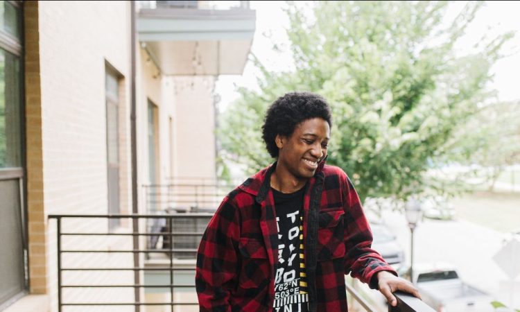 Portrait of person standing on apartment balcony