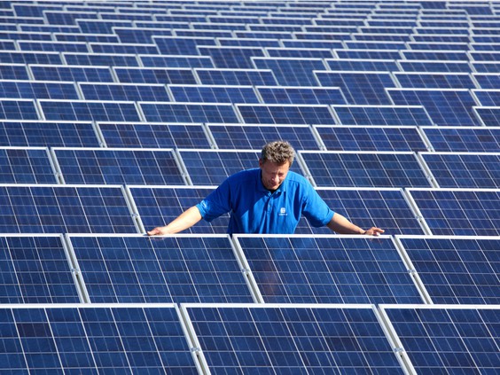 Worker amid array of solar panels