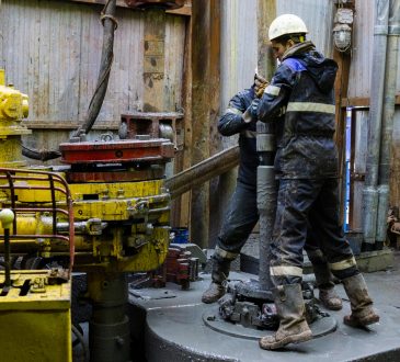 Offshore oil rig workers prepare tool and equipment for perforation at wellhead platform.