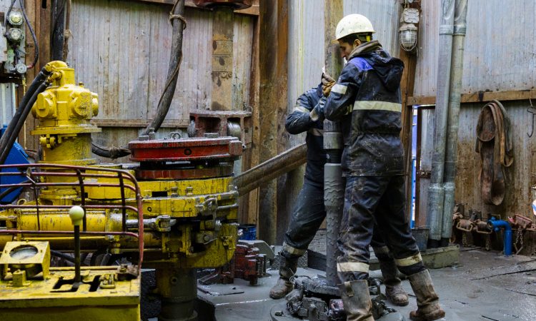 Offshore oil rig workers prepare tool and equipment for perforation at wellhead platform.