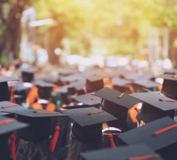 Top view of group of people wearing graduation caps outside