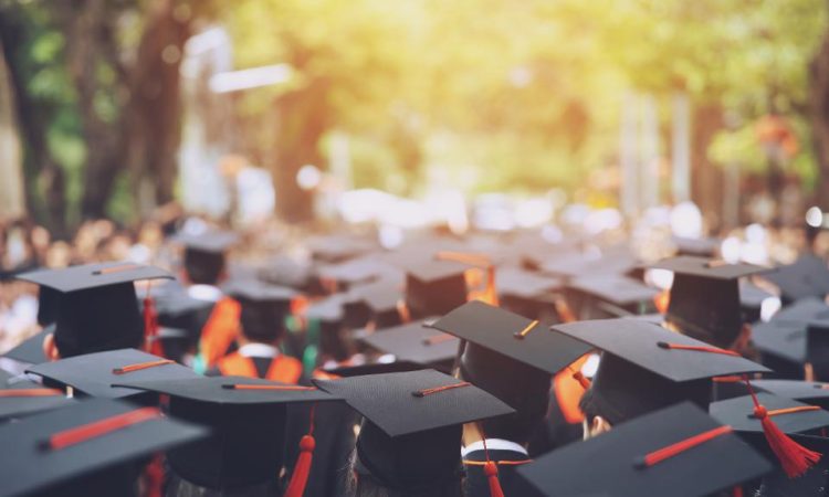 Top view of group of people wearing graduation caps outside