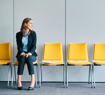 Woman sitting in yellow chair in waiting room of office