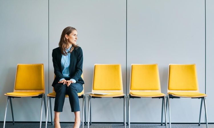 Woman sitting in yellow chair in waiting room of office