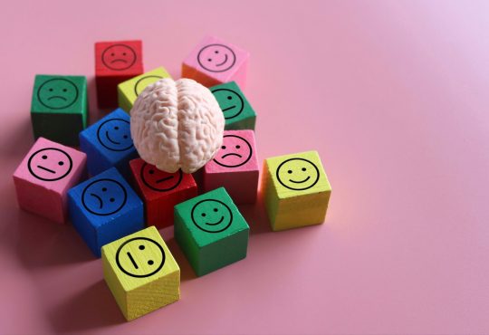 Human brain with blocks showing happy, neutral and sad icon.