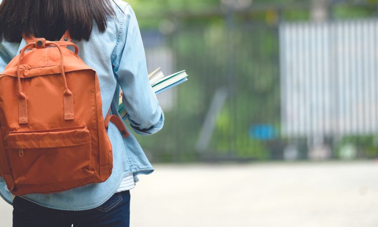 Back of student wearing backpack