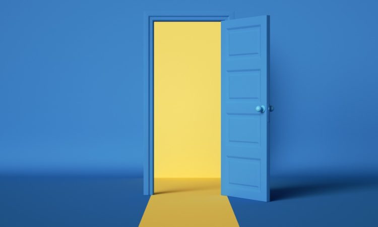 Yellow light emerging from open blue door