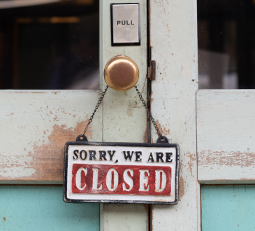 "Sorry, we are closed" written on a sign hanging from a doorhandle