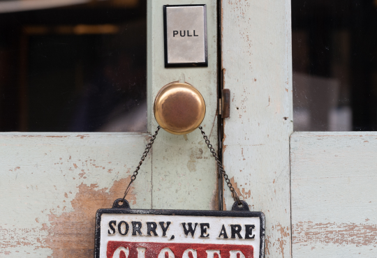 "Sorry, we are closed" written on a sign hanging from a doorhandle