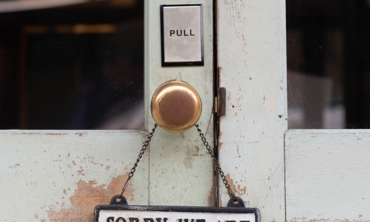 "Sorry, we are closed" written on a sign hanging from a doorhandle
