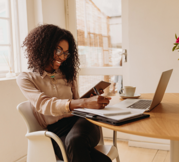 Woman working from home with laptop, notes, and tablet