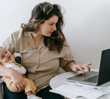 Woman working from home with baby in hand