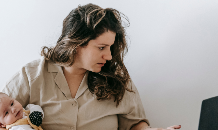Woman working from home with baby in hand