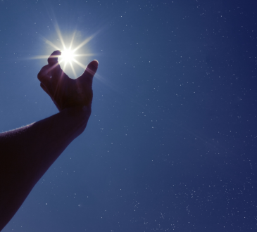 Hand reaching for brightest star in the sky