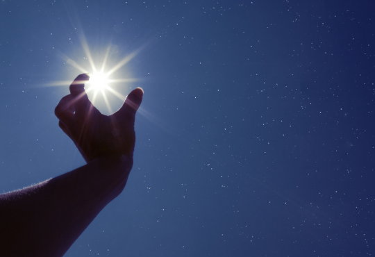 Hand reaching for brightest star in the sky