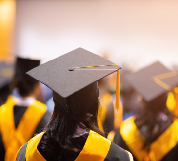 Students seated in graduation regalia with caps and gown