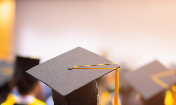 Students seated in graduation regalia with caps and gown