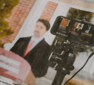 Blurry image of newspaper extract picturing Justin Trudeau at a podium making a speech about COVID-19