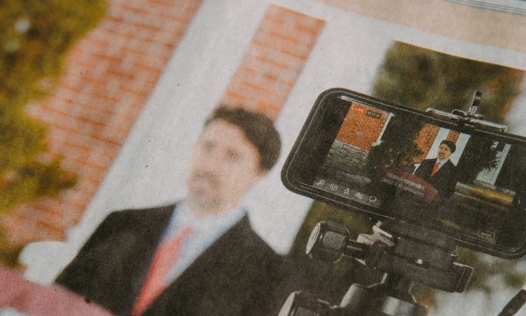 Blurry image of newspaper extract picturing Justin Trudeau at a podium making a speech about COVID-19