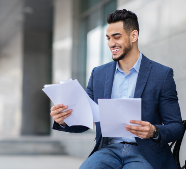 Man in blazer preparing for interview by reading papers