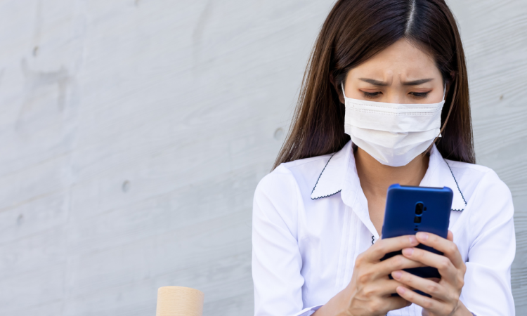 Woman sitting down using phone after getting fired due to pandemic layoffs