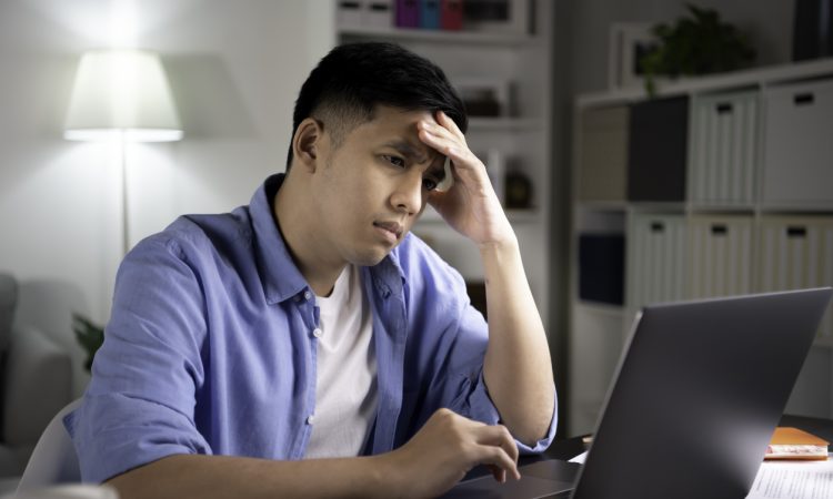 Man sitting at desk looking stressed