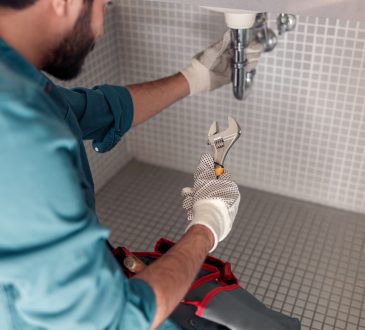 Worker is repairing bathroom sink