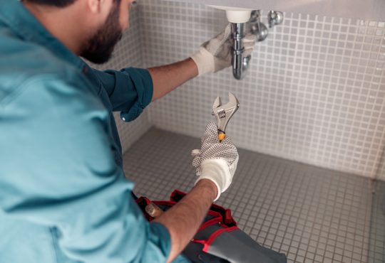 Worker is repairing bathroom sink